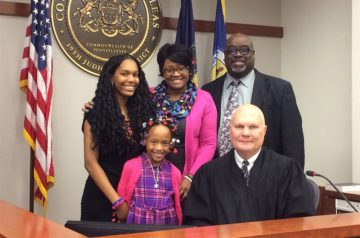 People standing in a courtroom.